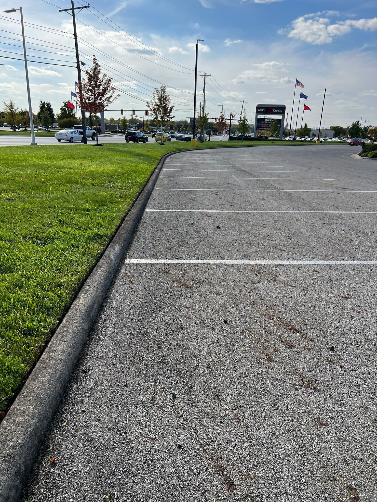 A parking lot with cars parked in it and a grassy area in the background.