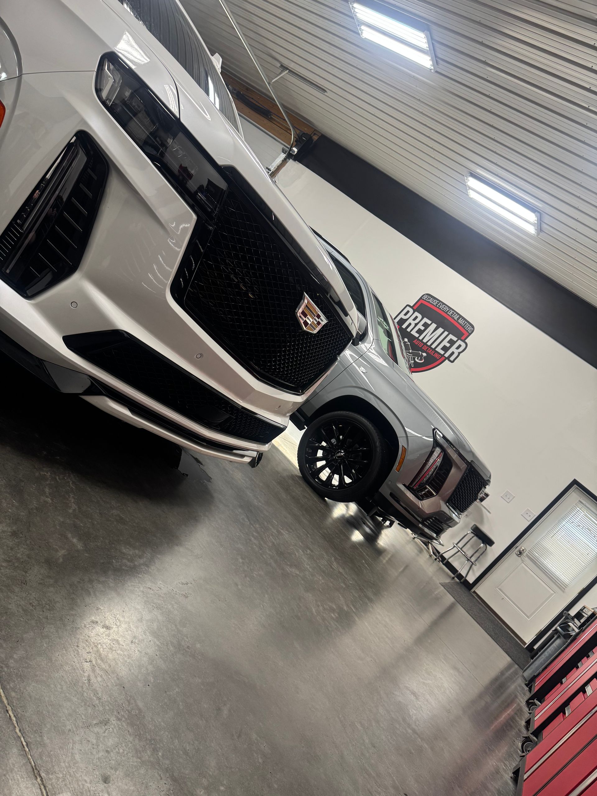White Cadillac SUV being washed at Premier Detailing shop.