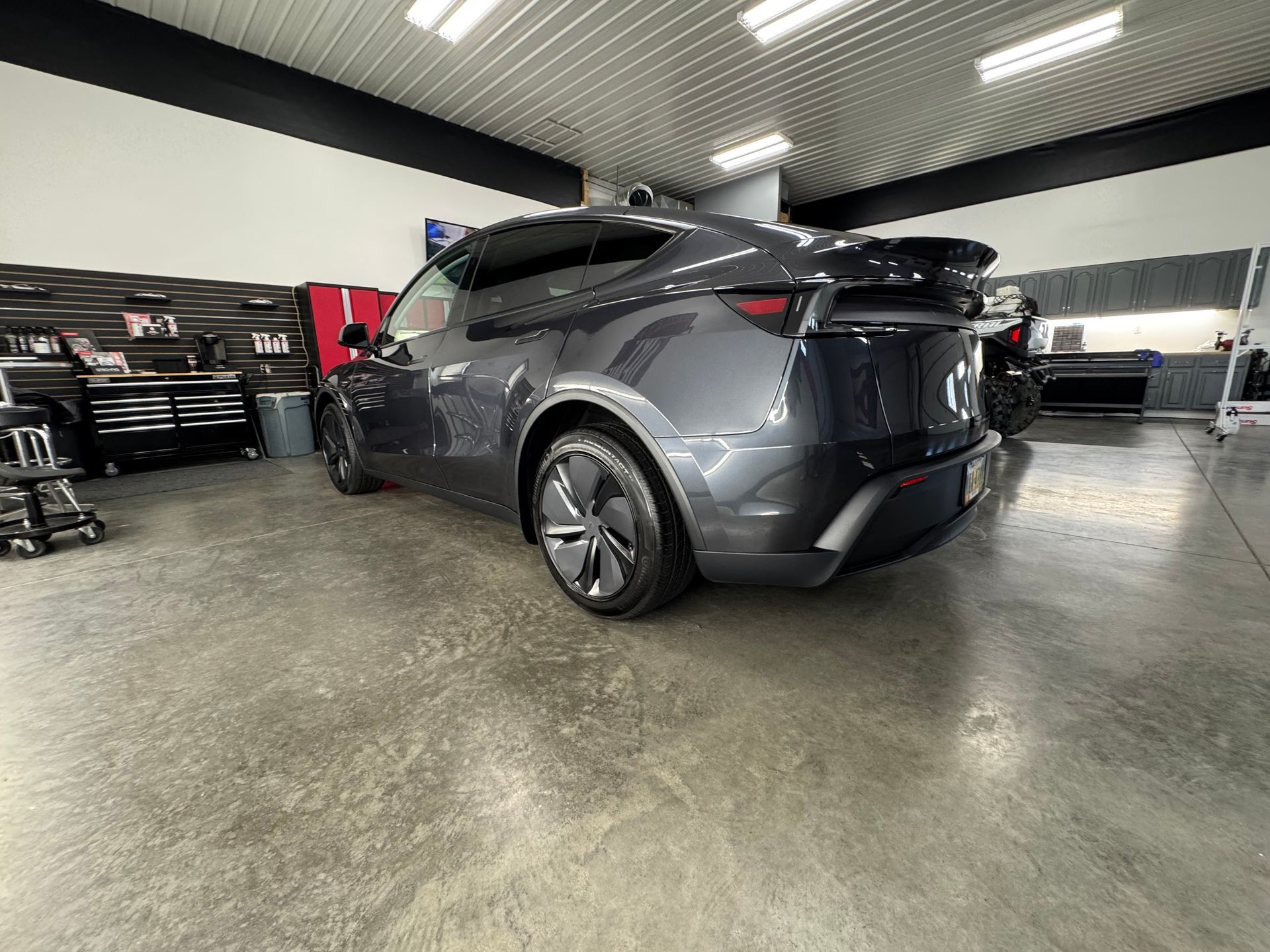 Dark gray electric SUV in a garage, showcasing its rear and side profile.
