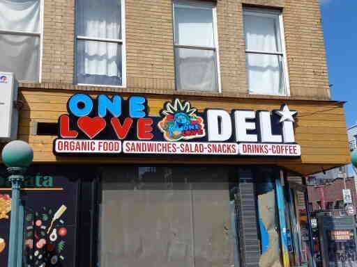 A building with a sign that says one love deli on it.