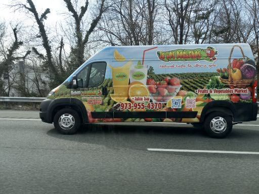 A fruit and vegetable van is driving down a highway