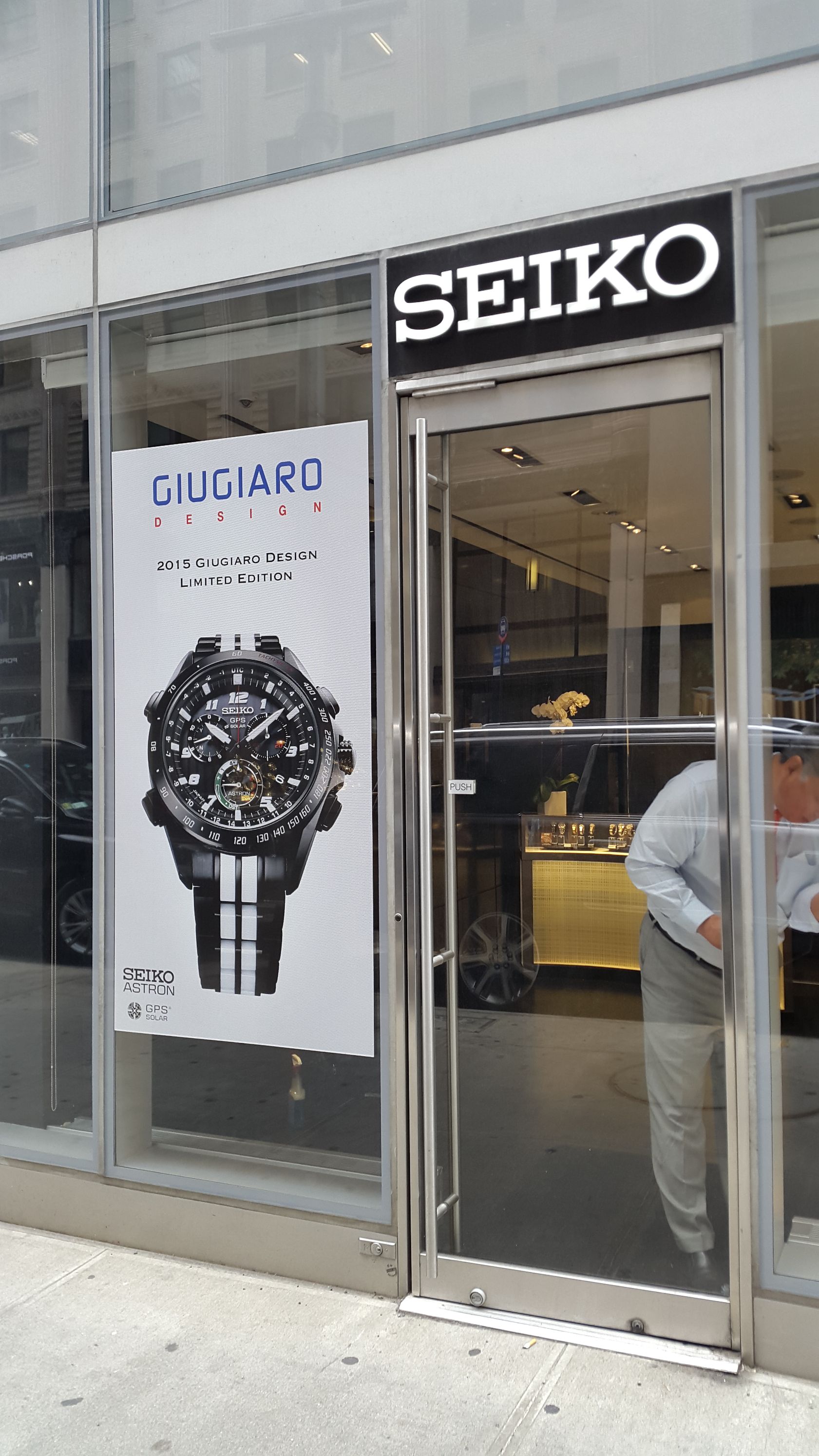 A seiko store with a man standing in front of it