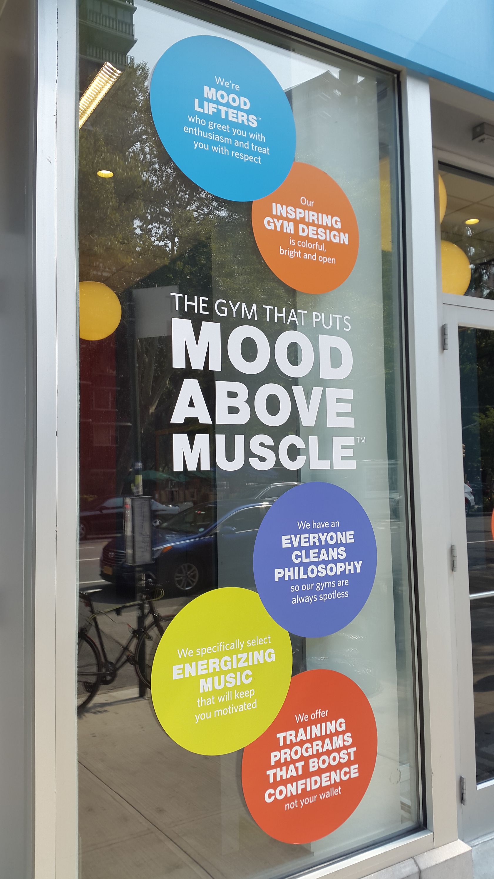 A window with stickers on it that say mood above muscle