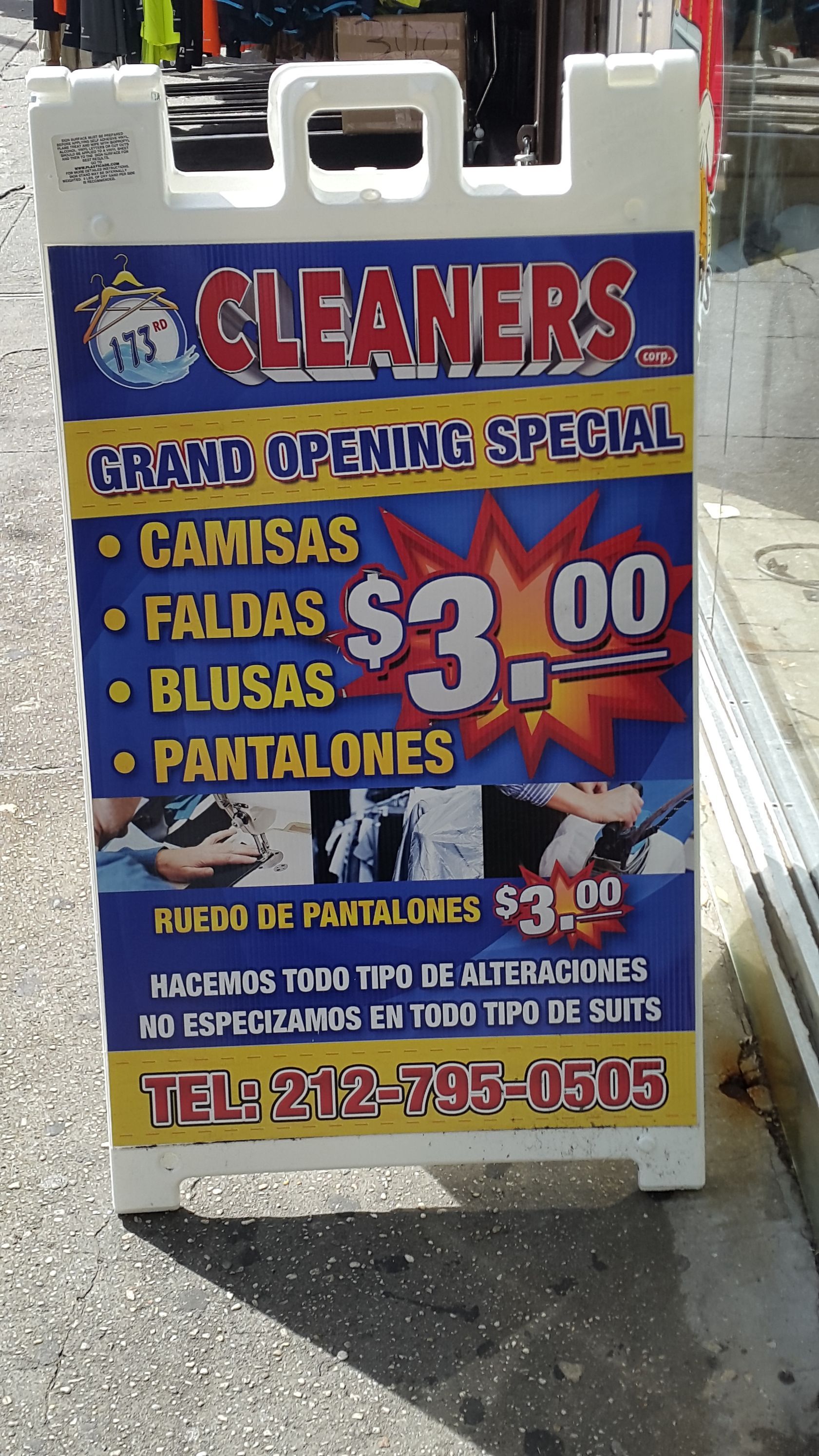 A sign for cleaners advertises their grand opening special