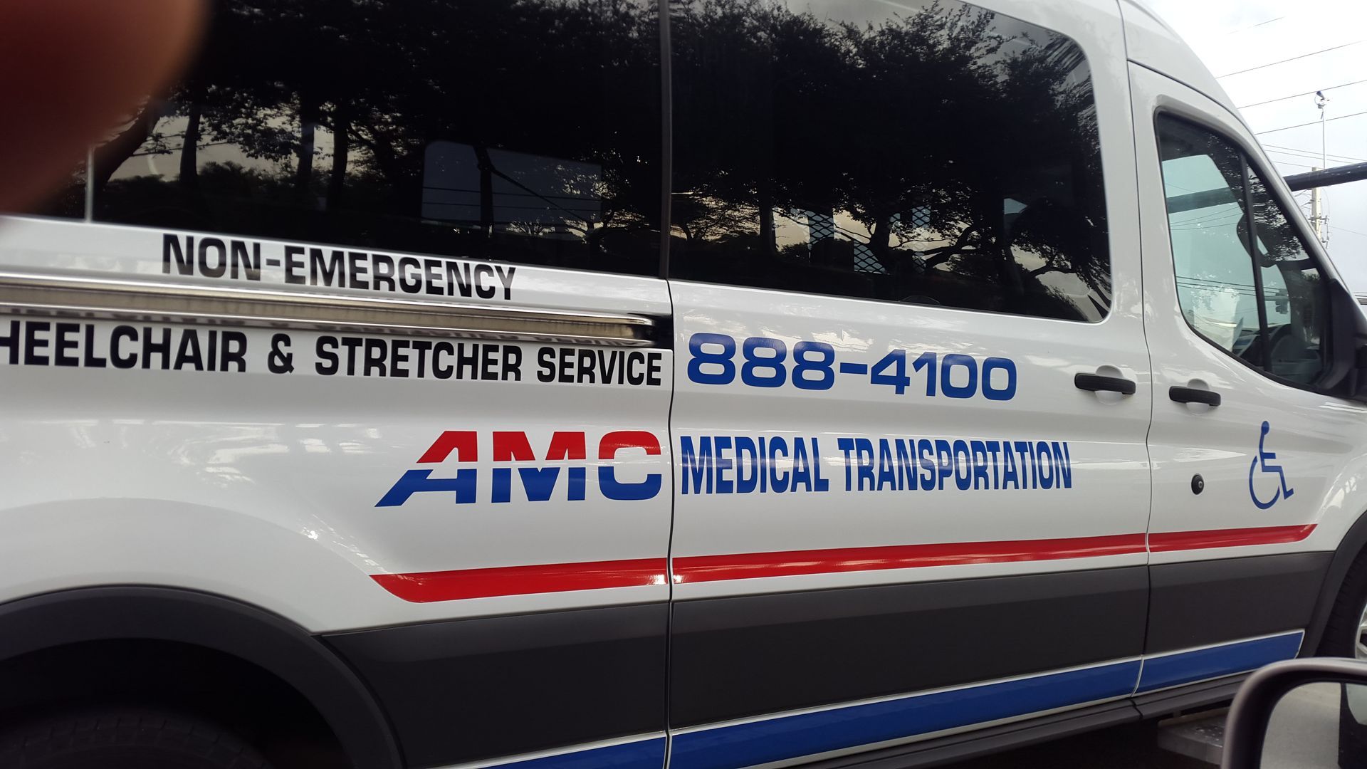 A white van says amc medical transportation on the side