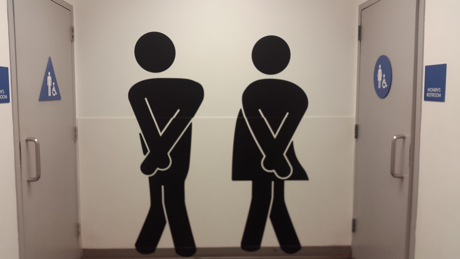 A man and a woman are standing next to each other in a bathroom