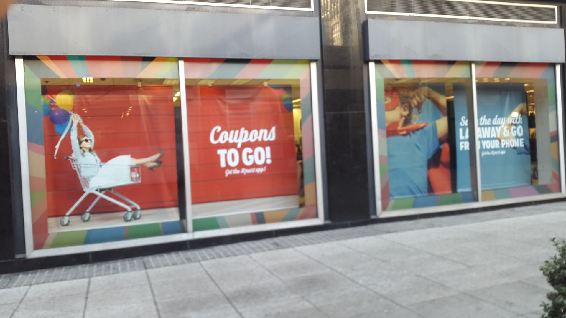 A store front with a sign that says coupons to go