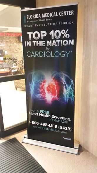 A banner that says `` top 10 % in the nation of cardiology '' is hanging on a wall.