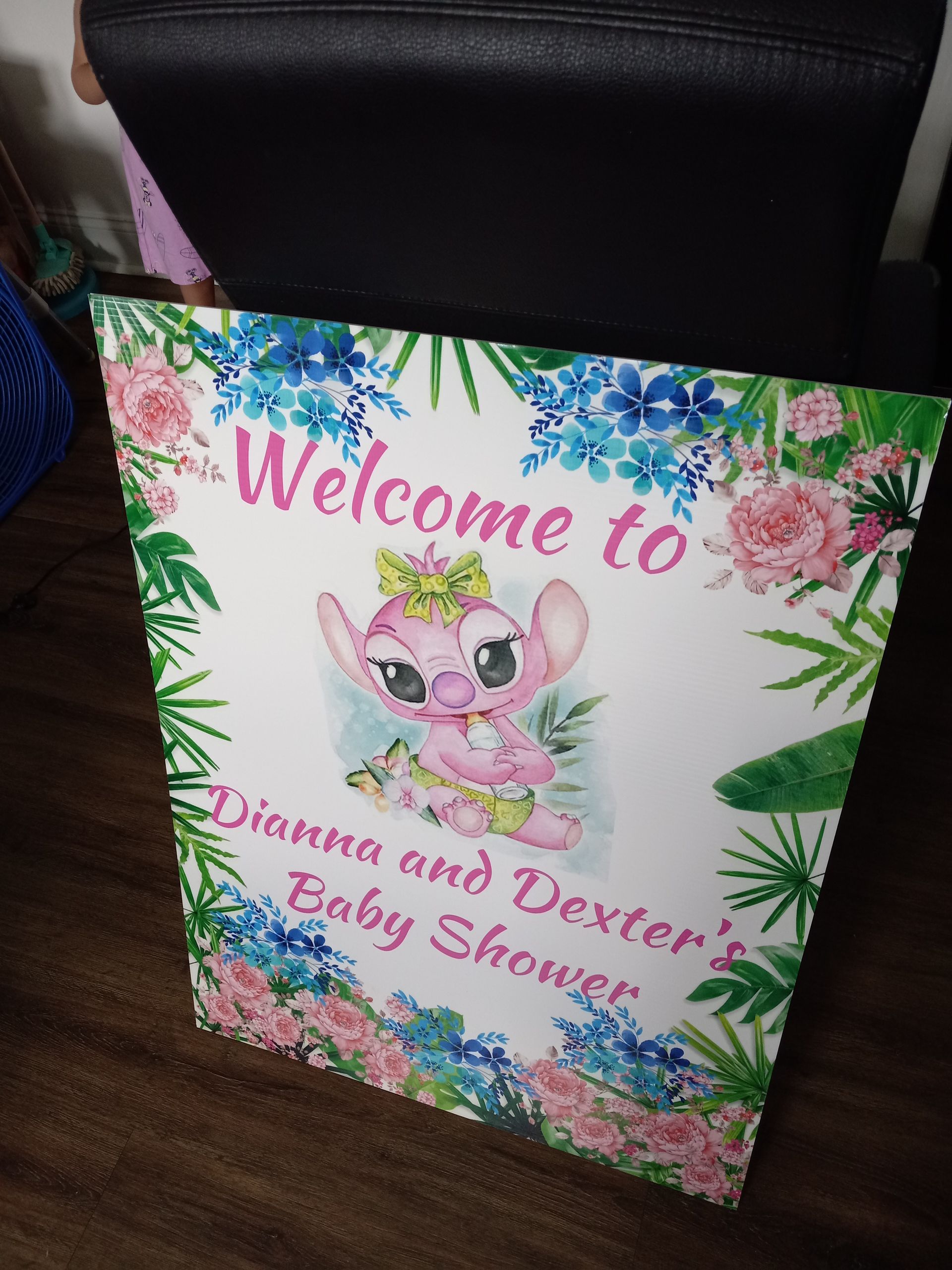 A welcome to dianna and dexter 's baby shower sign is sitting on a wooden table.