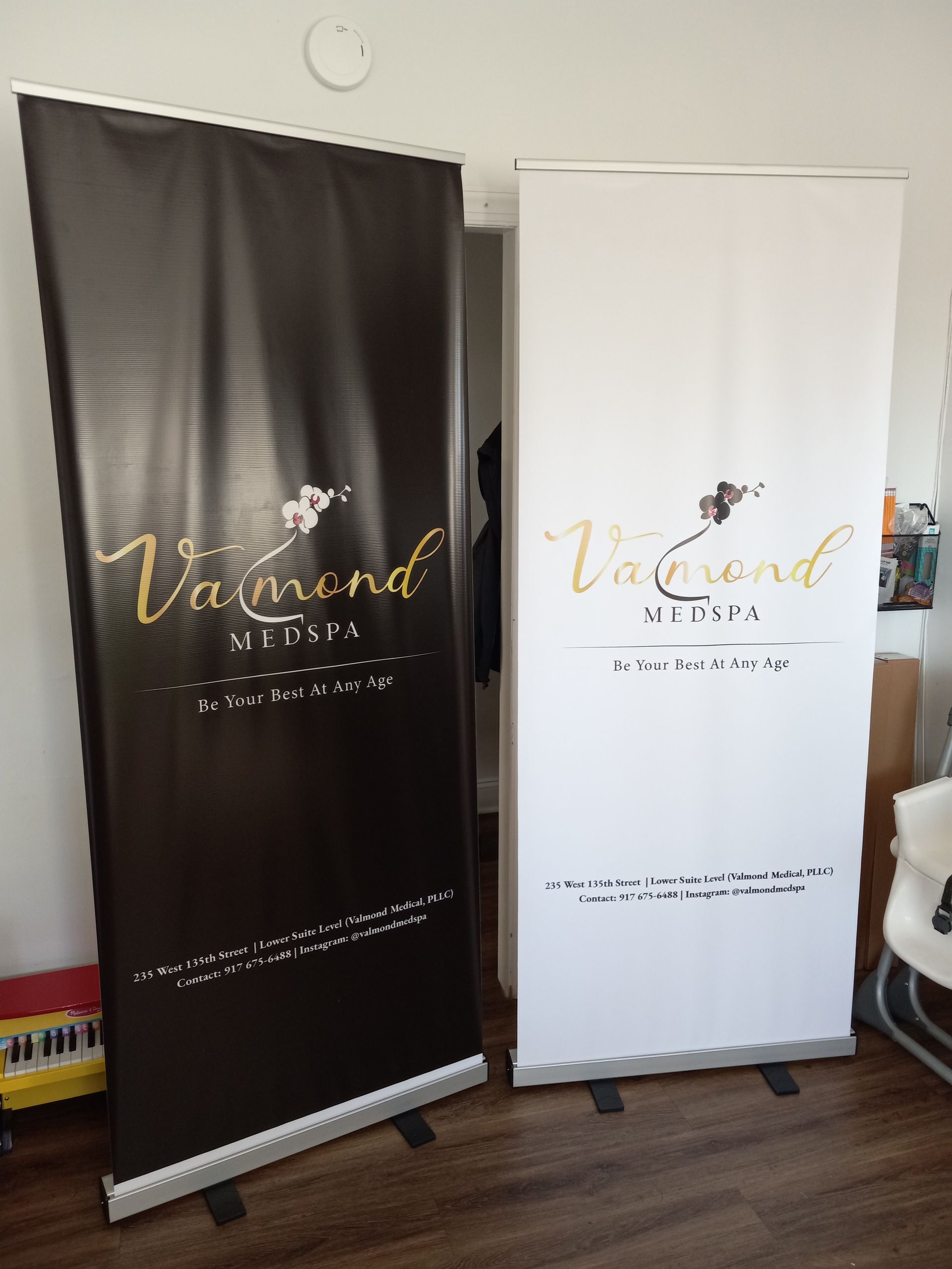 Two roll up banners are sitting next to each other in a room.