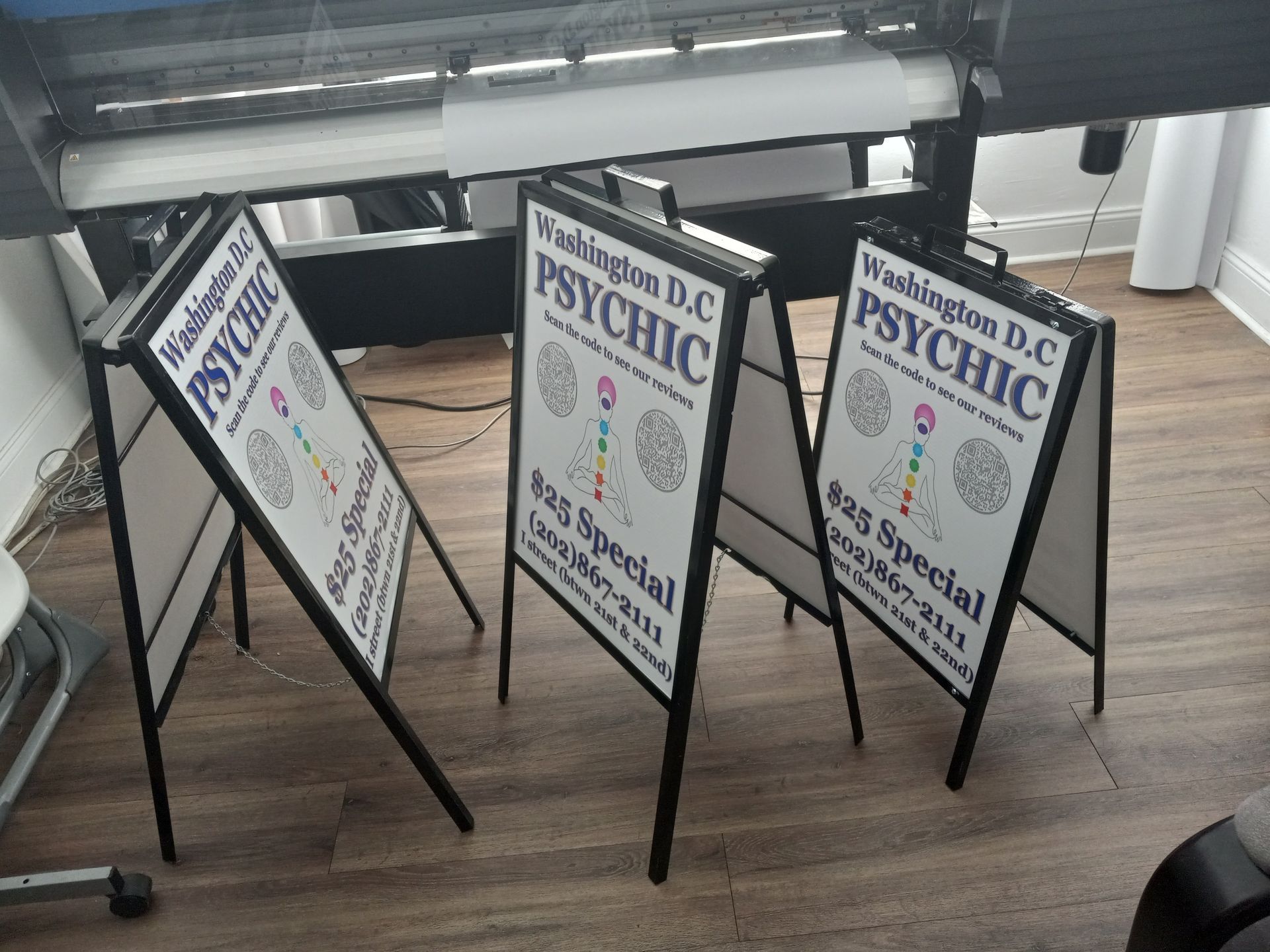 Three a frame signs for washington dc psychic are sitting on a wooden floor