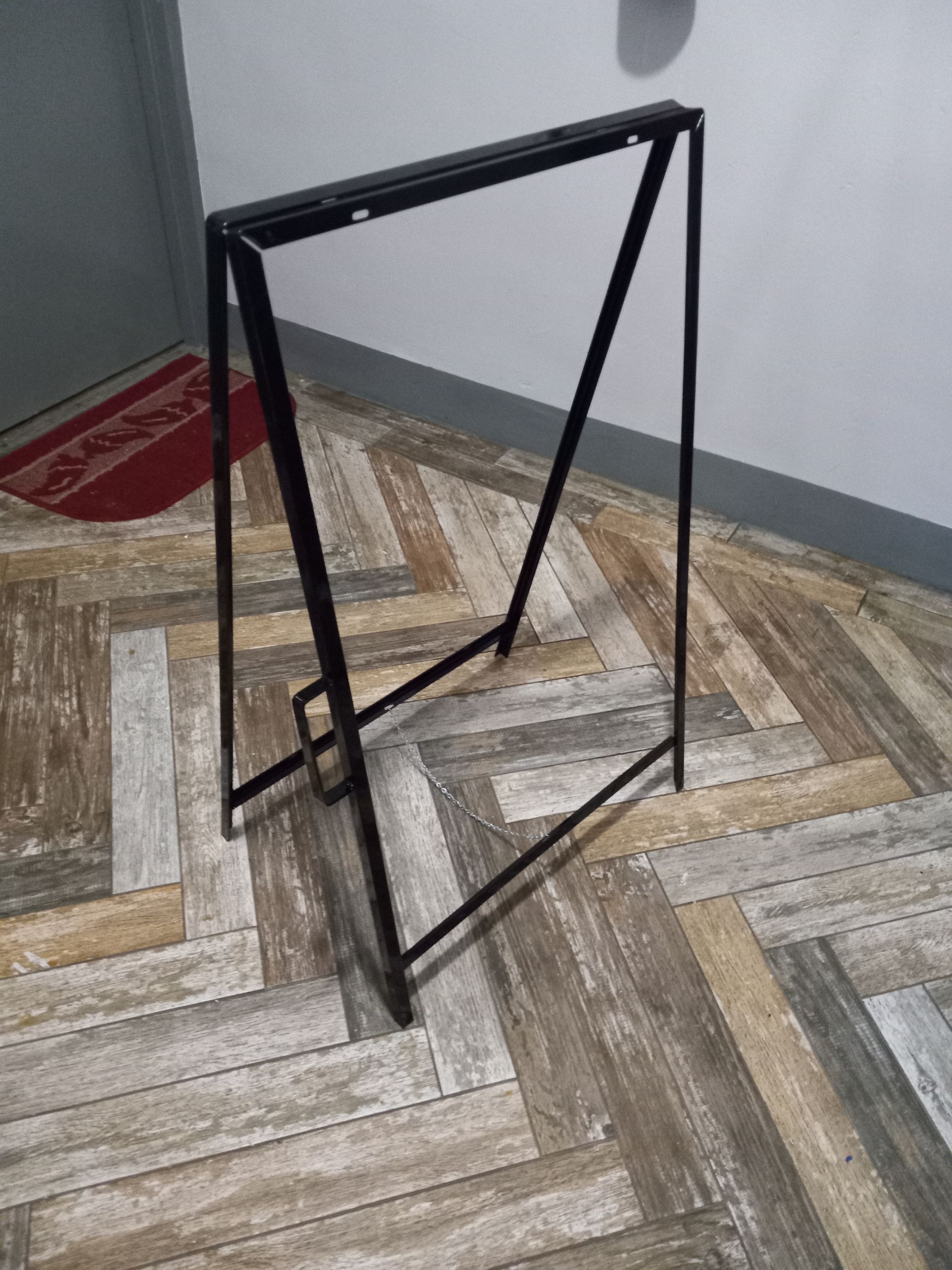 A metal frame is sitting on a wooden floor.