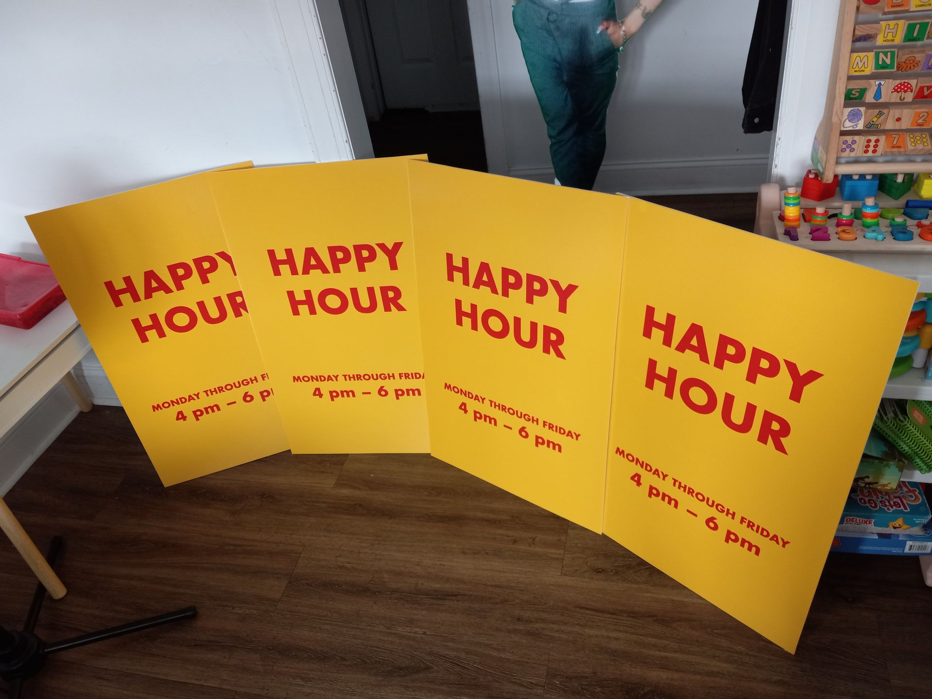 A row of yellow signs that say happy hour