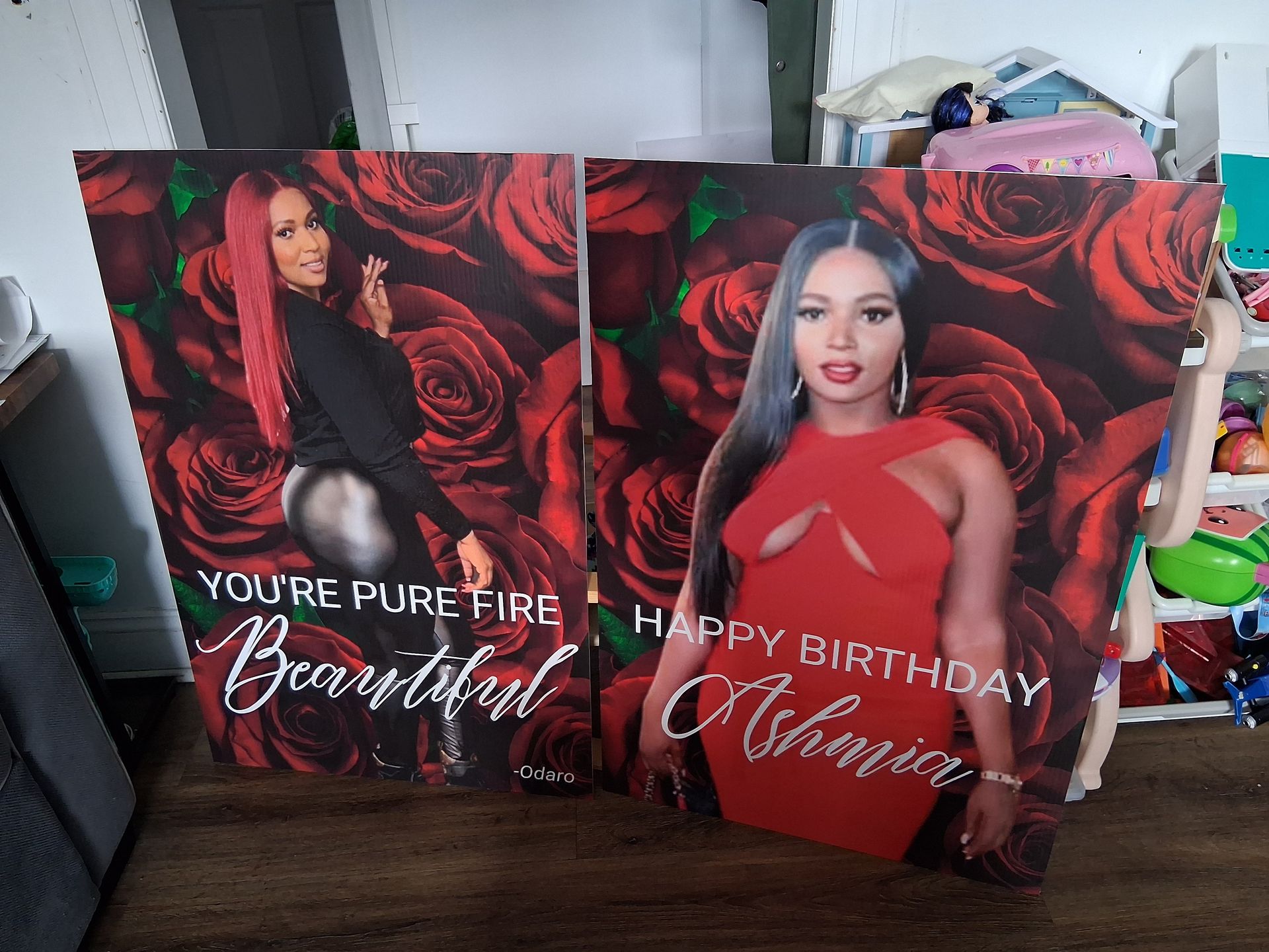 Two paintings of a woman in a red dress are sitting on a wooden floor.