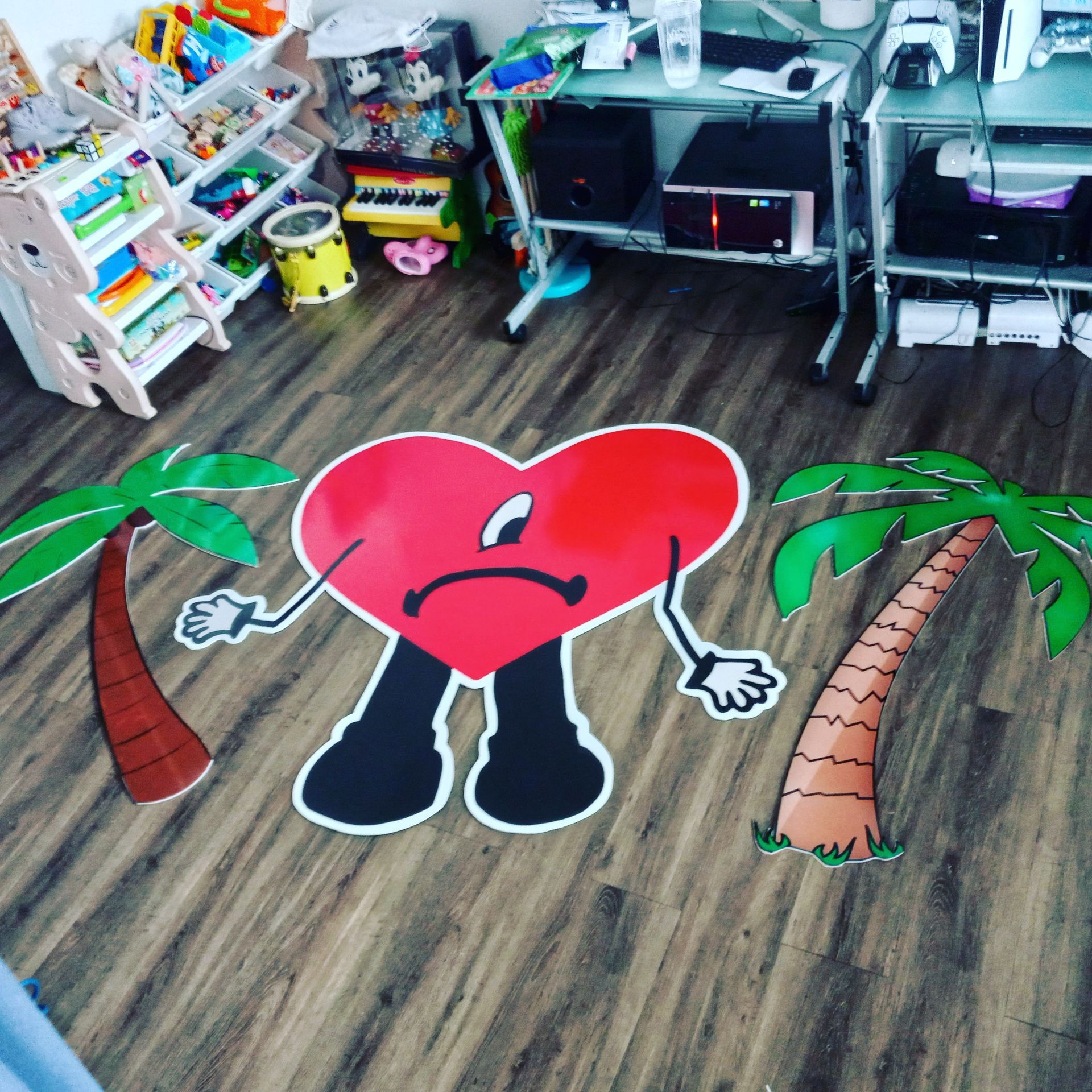 A red heart with arms and legs and palm trees painted on the floor