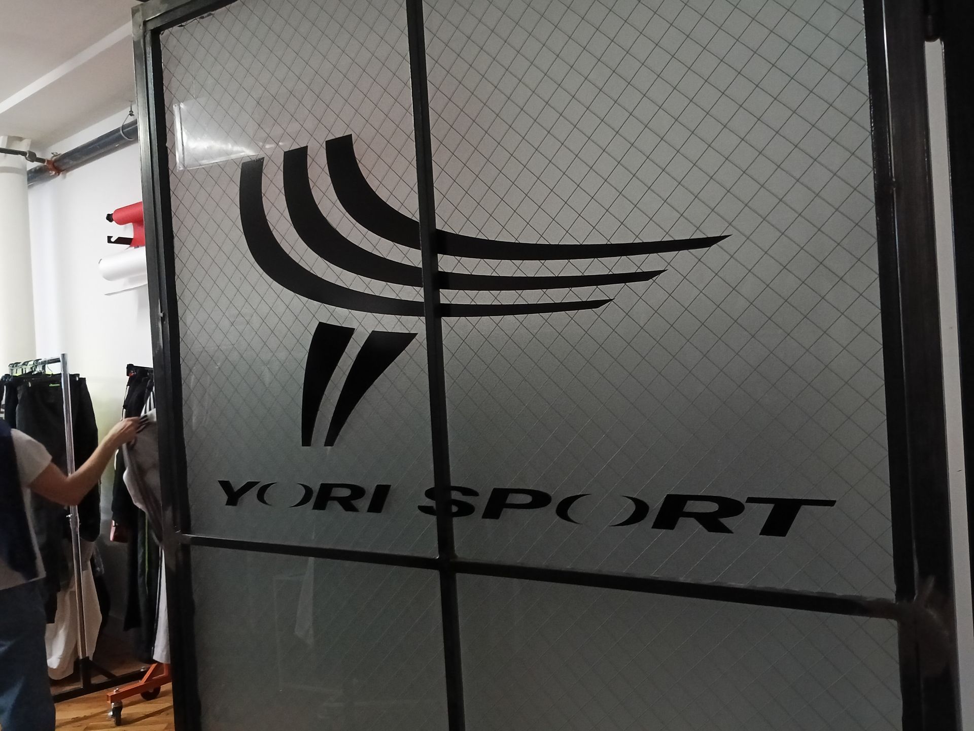 A person is standing in front of a door that says yuri sport