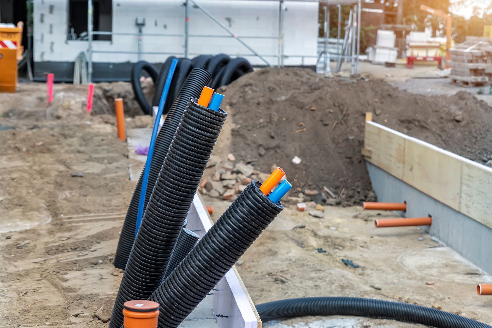 Black PVC flexible corrugated plastic insulation pipes and tubing encasing electrical cables and wires in an underground installation.