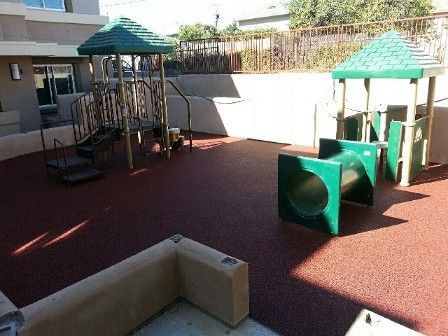 A playground with a green slide and stairs