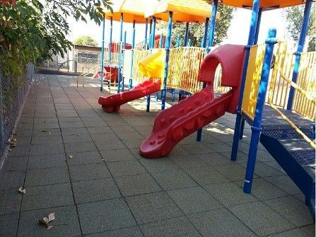 A playground with a red slide in the middle