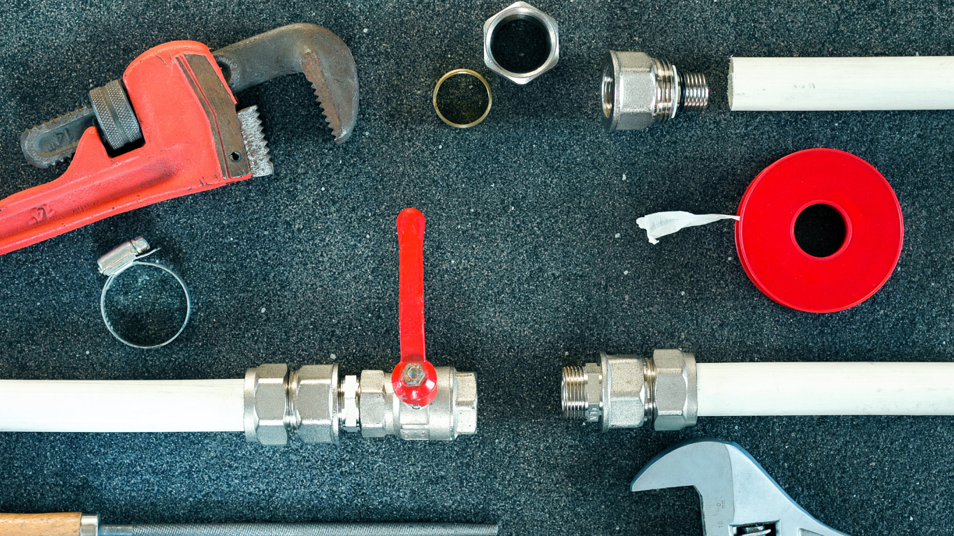 A bunch of plumbing tools are sitting on a black surface.