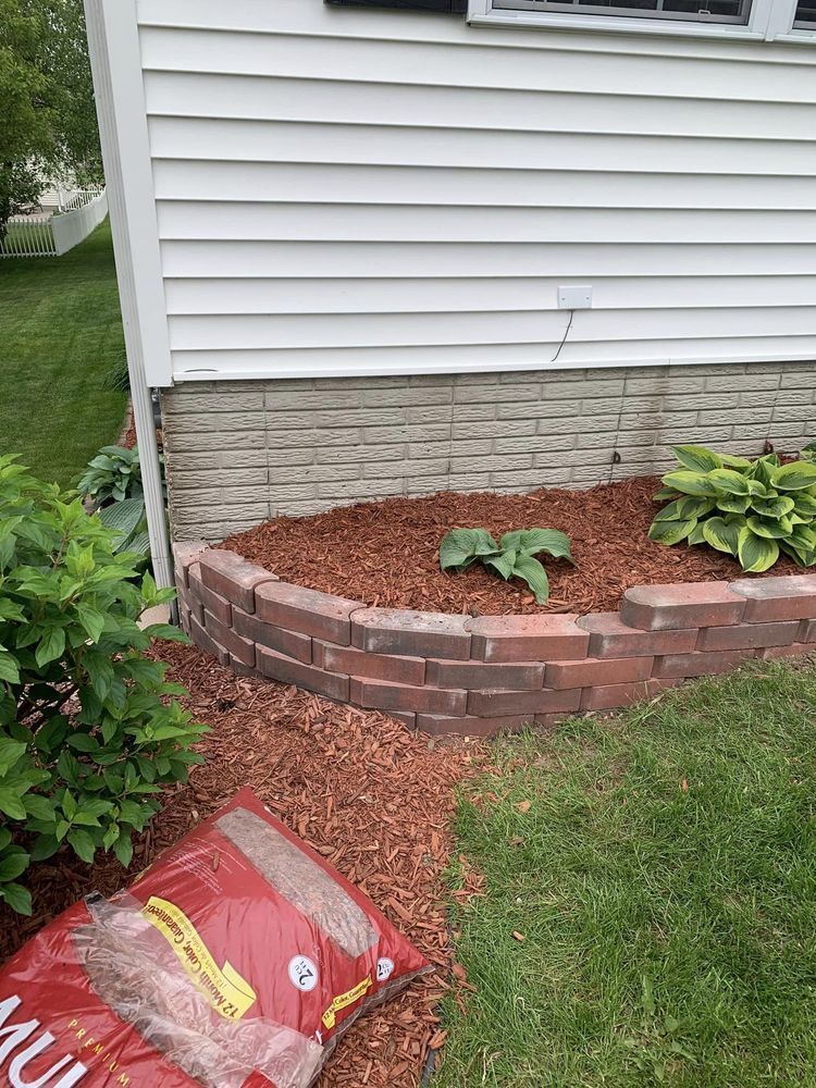 A bag of mulch is sitting in front of a house.