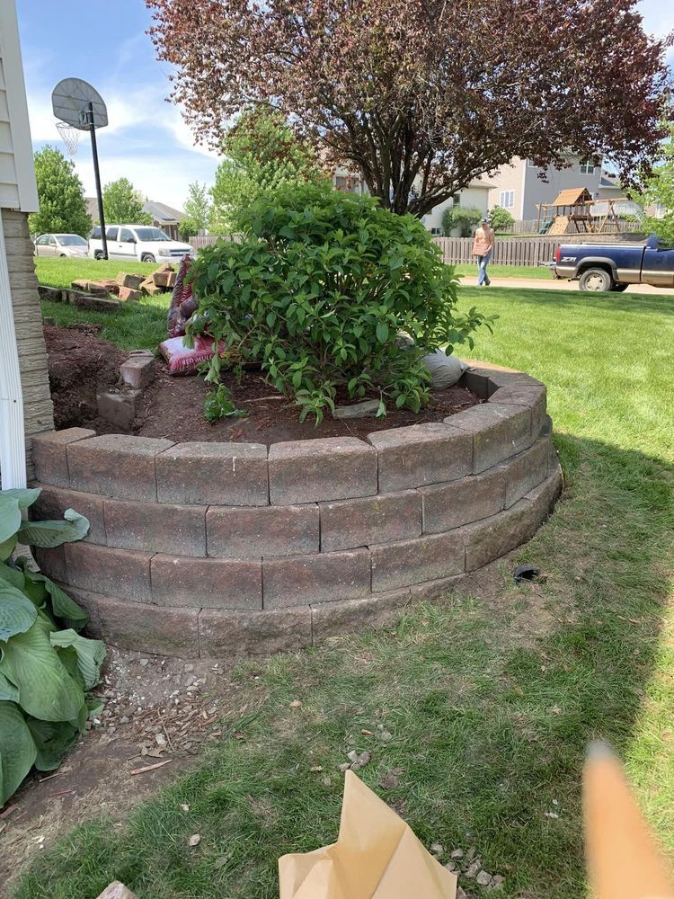 A brick wall is being built in the backyard of a house.