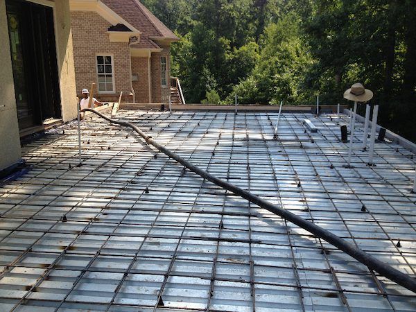 A concrete floor is being built in front of a house