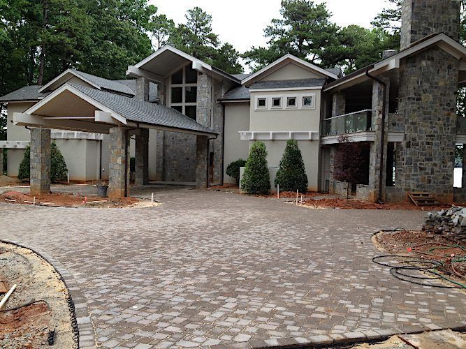 A large house with a brick driveway in front of it