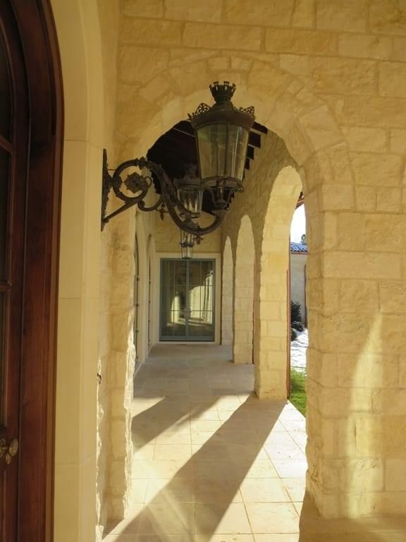 A hallway with arches and a lantern on the wall