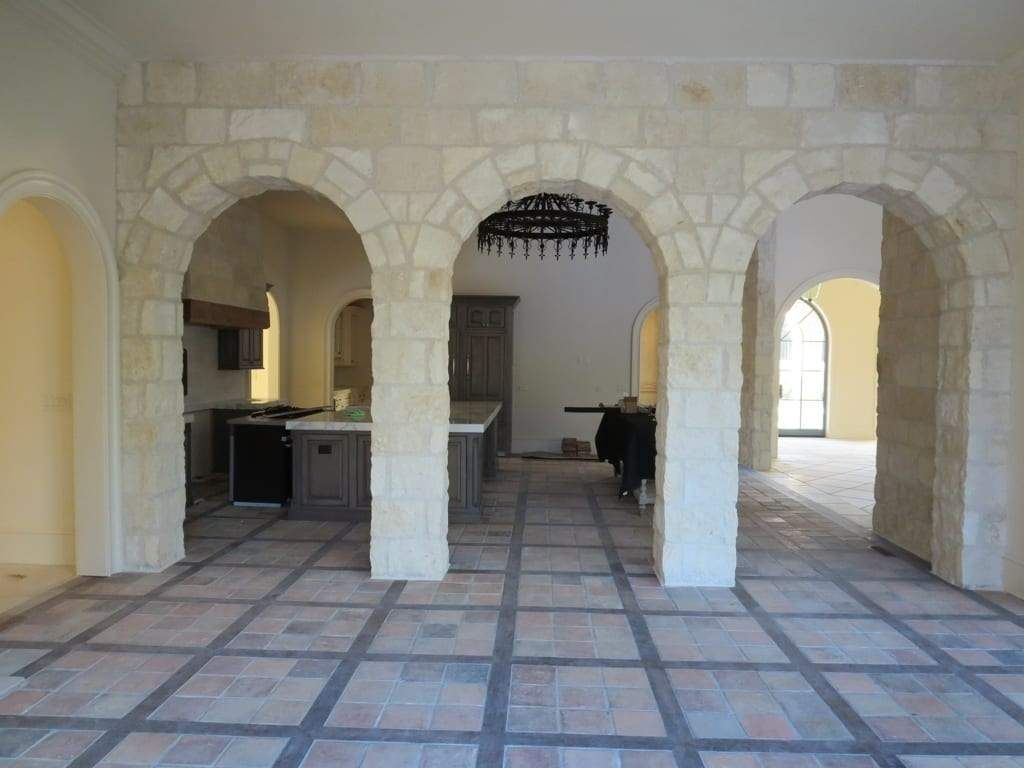 An empty room with arches and a tiled floor
