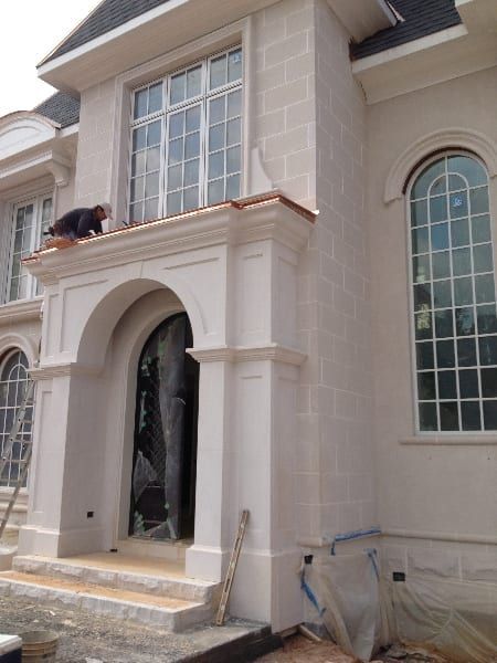 A man is standing on the roof of a white house