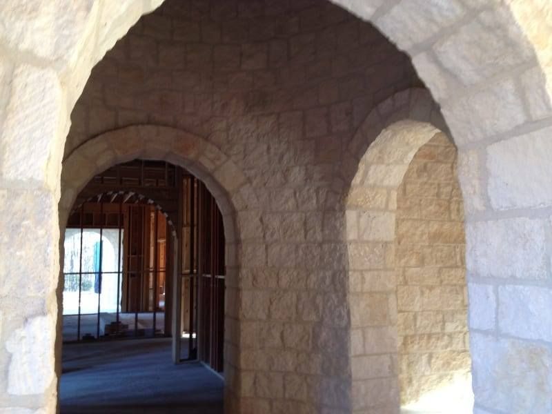 A brick archway leading to a building under construction
