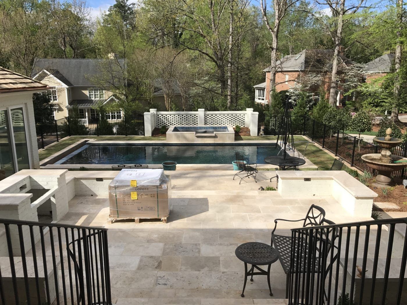 There is a large swimming pool in the backyard of a house