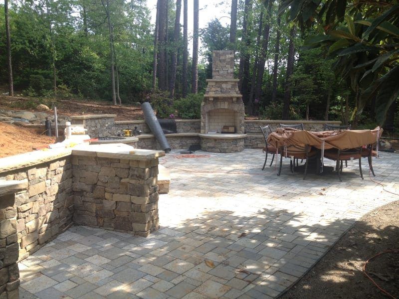 A patio with a fireplace and a table and chairs
