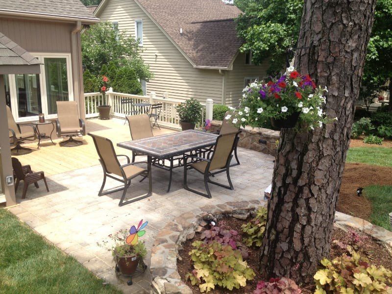 A patio with a table and chairs in front of a house