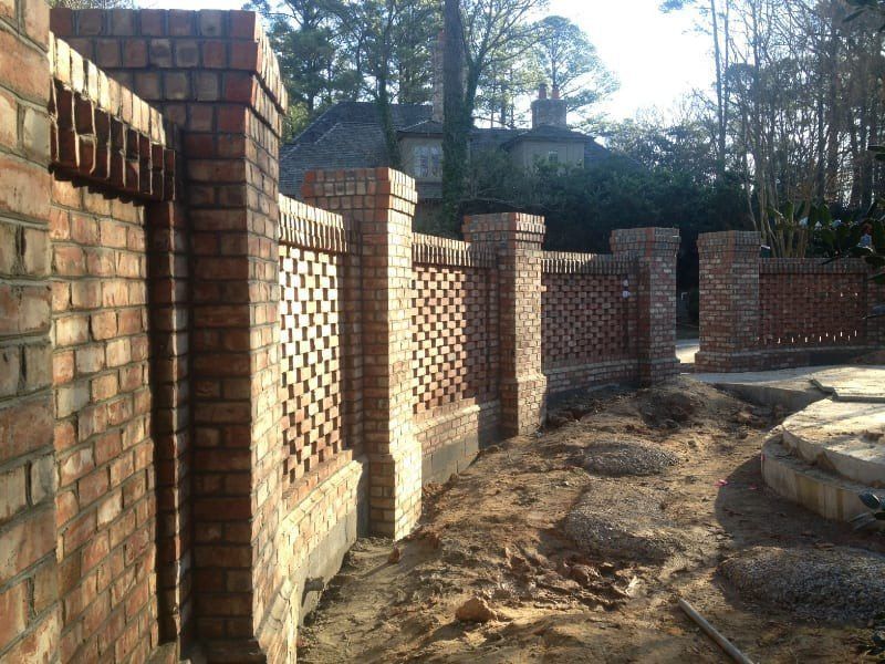 A brick wall is being built in front of a house