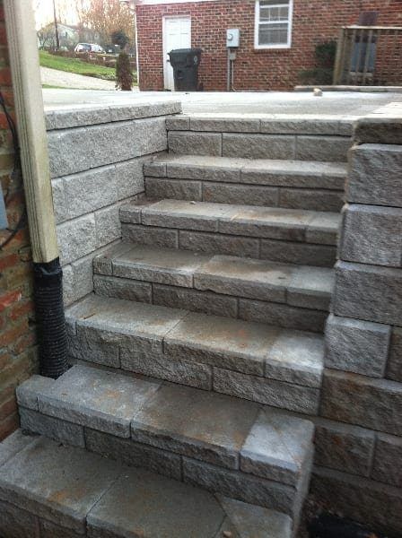 A set of stone stairs leading up to a brick wall