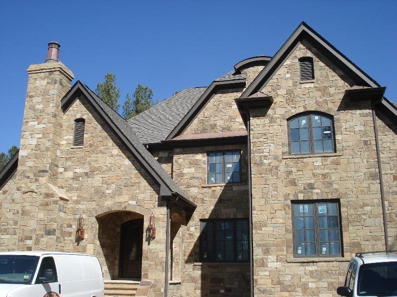 A large brick house with a white van parked in front of it