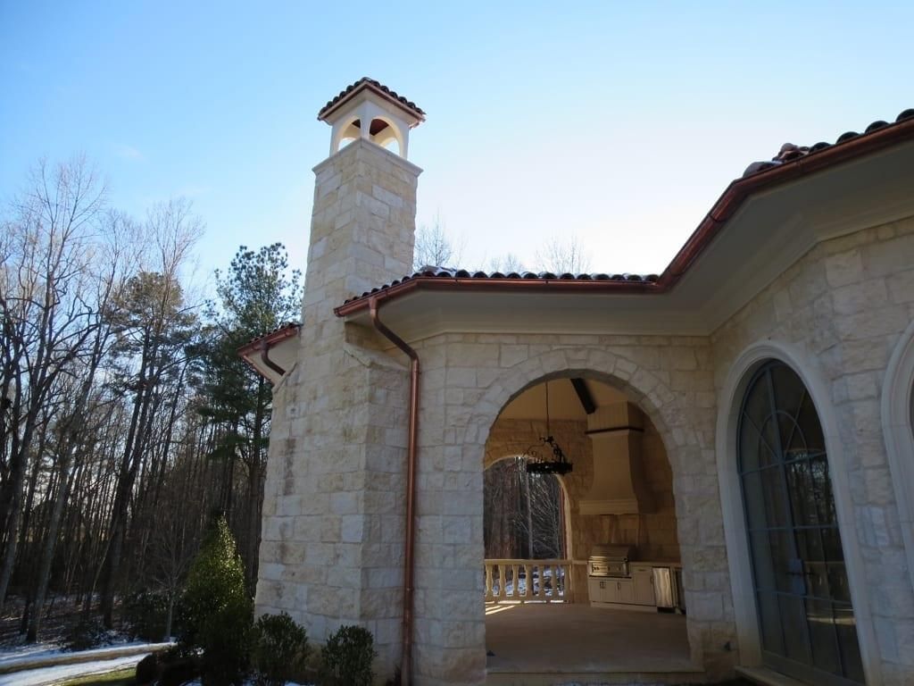 A large stone building with a chimney on top of it