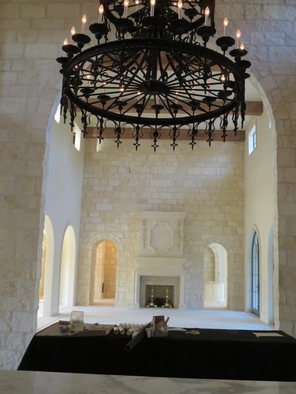 A large room with a fireplace and a chandelier hanging from the ceiling