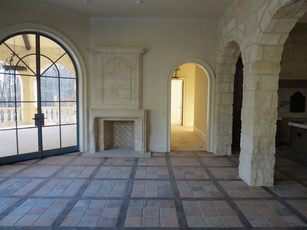 An empty room with arched windows and a fireplace