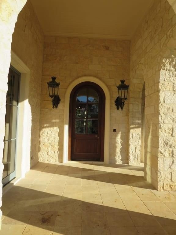 A porch with a wooden door and two lanterns
