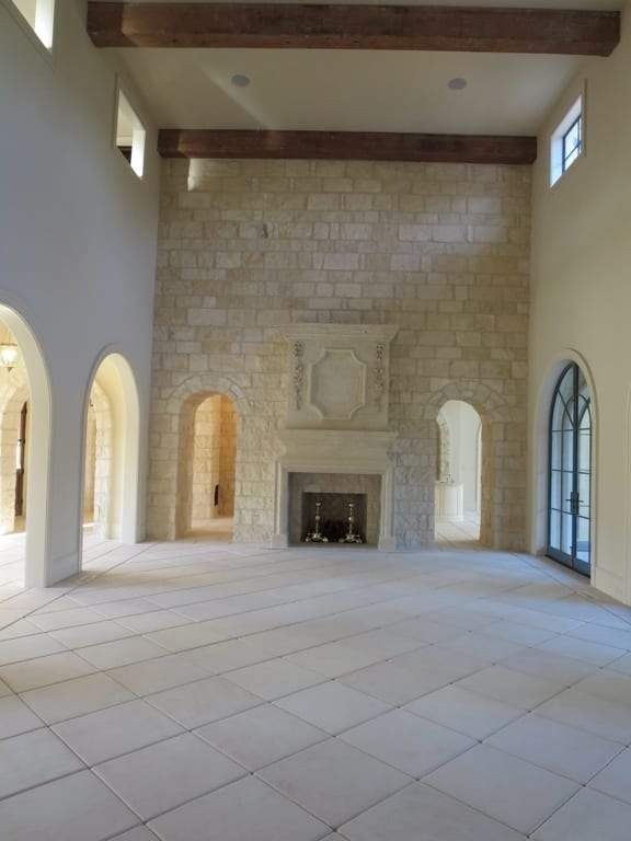 A large empty room with arches and a fireplace
