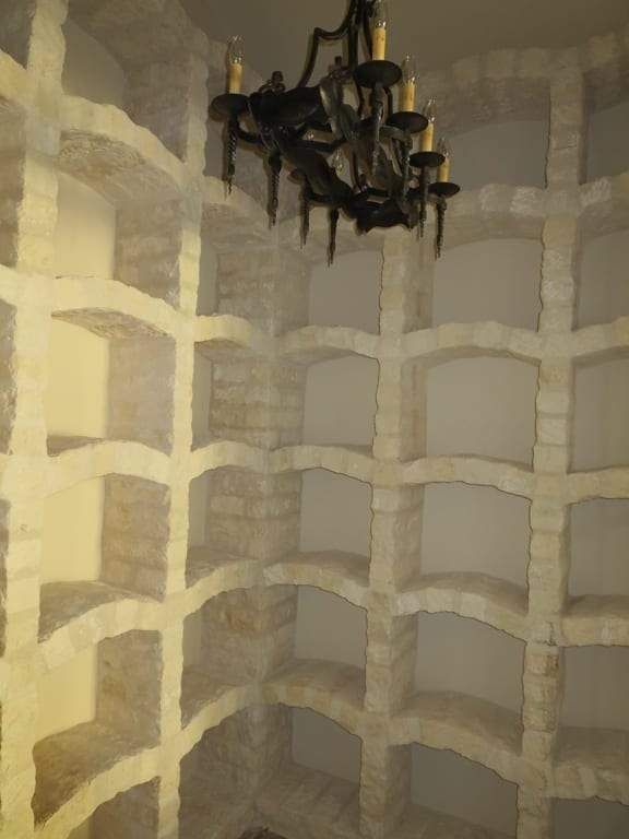 A room with a lot of shelves and a chandelier hanging from the ceiling