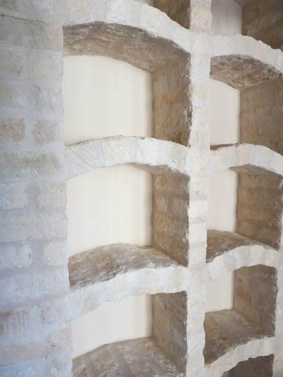 A brick wall with a row of shelves built into it