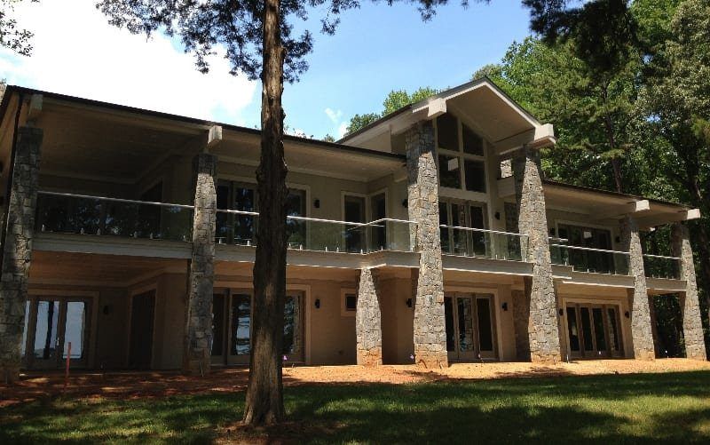 A large house with a lot of windows is surrounded by trees