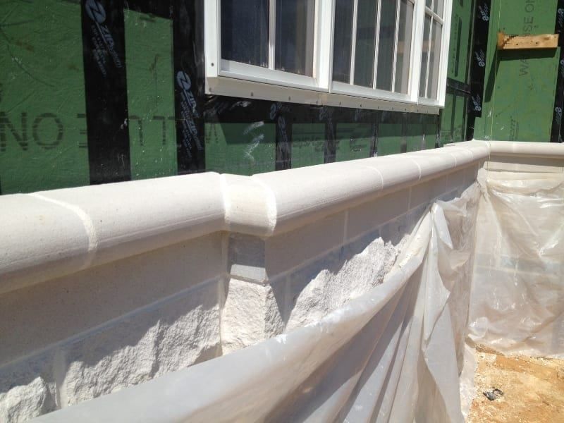 A white brick wall with a window in the background