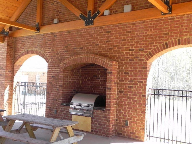 A brick building with a grill and a picnic table