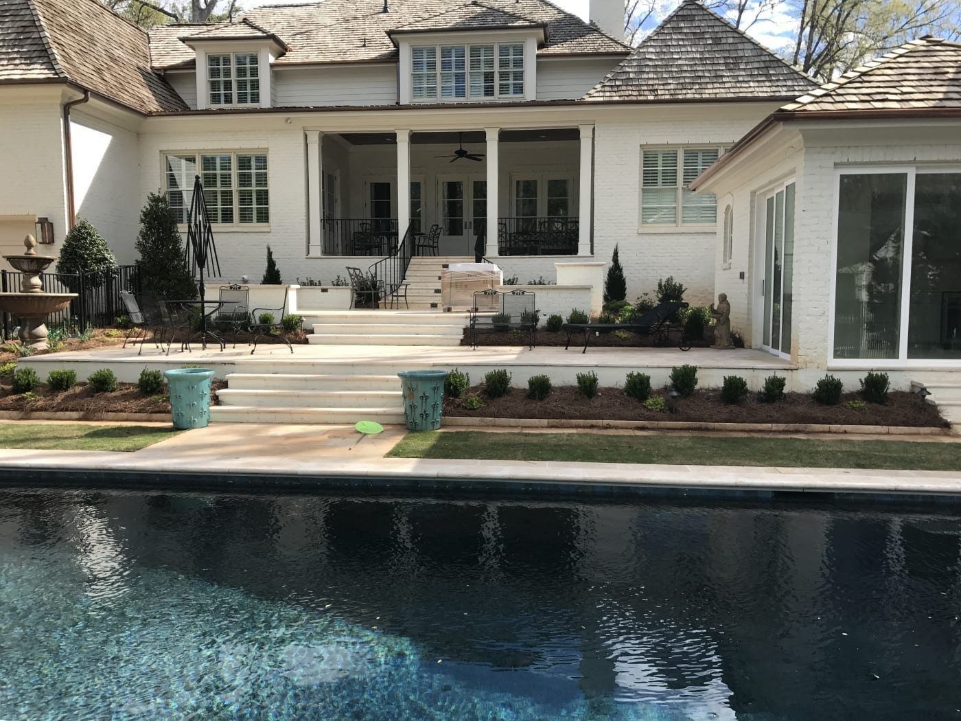 A large white house with a swimming pool in front of it