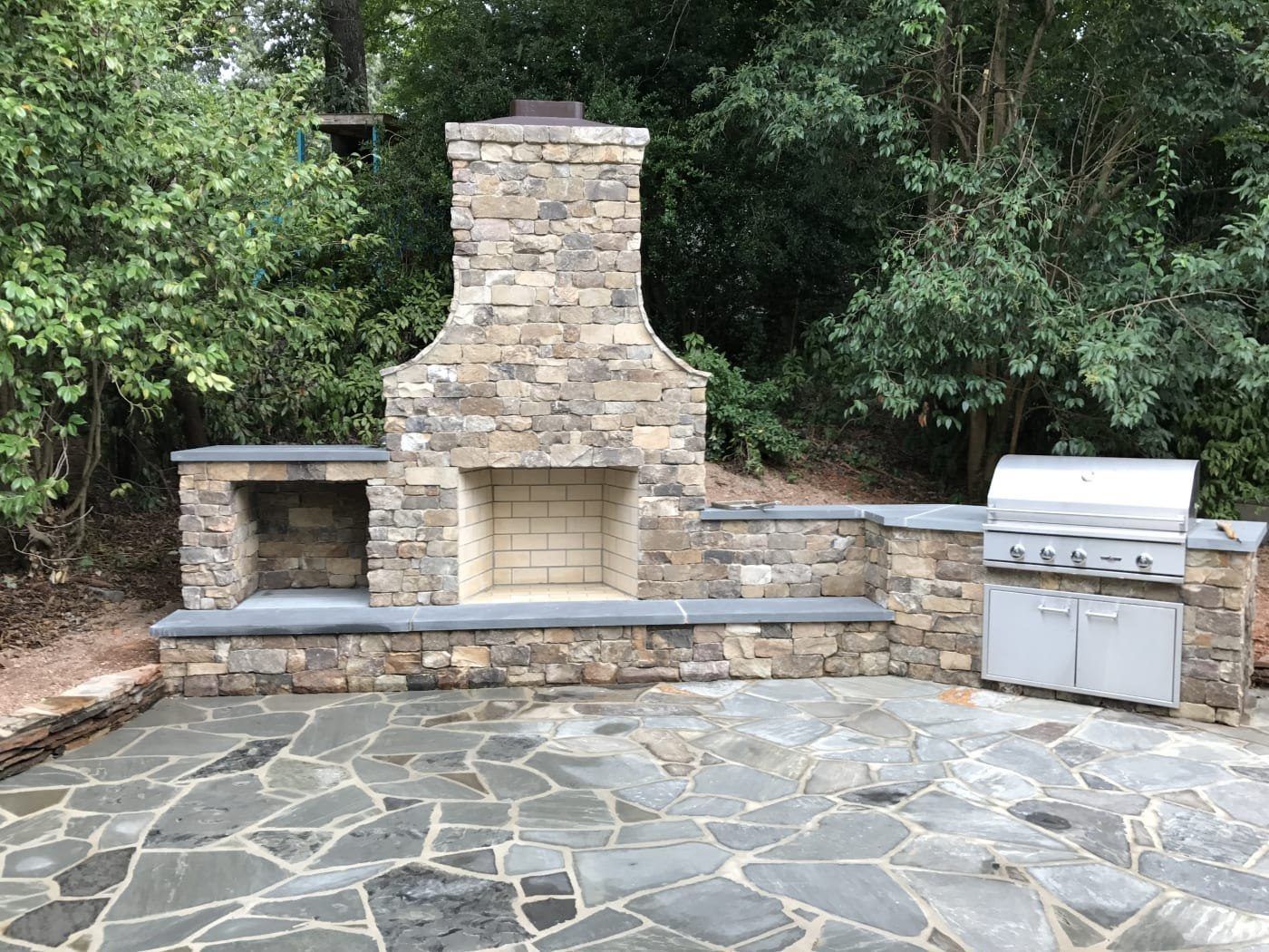 There is a fireplace and a grill on the patio